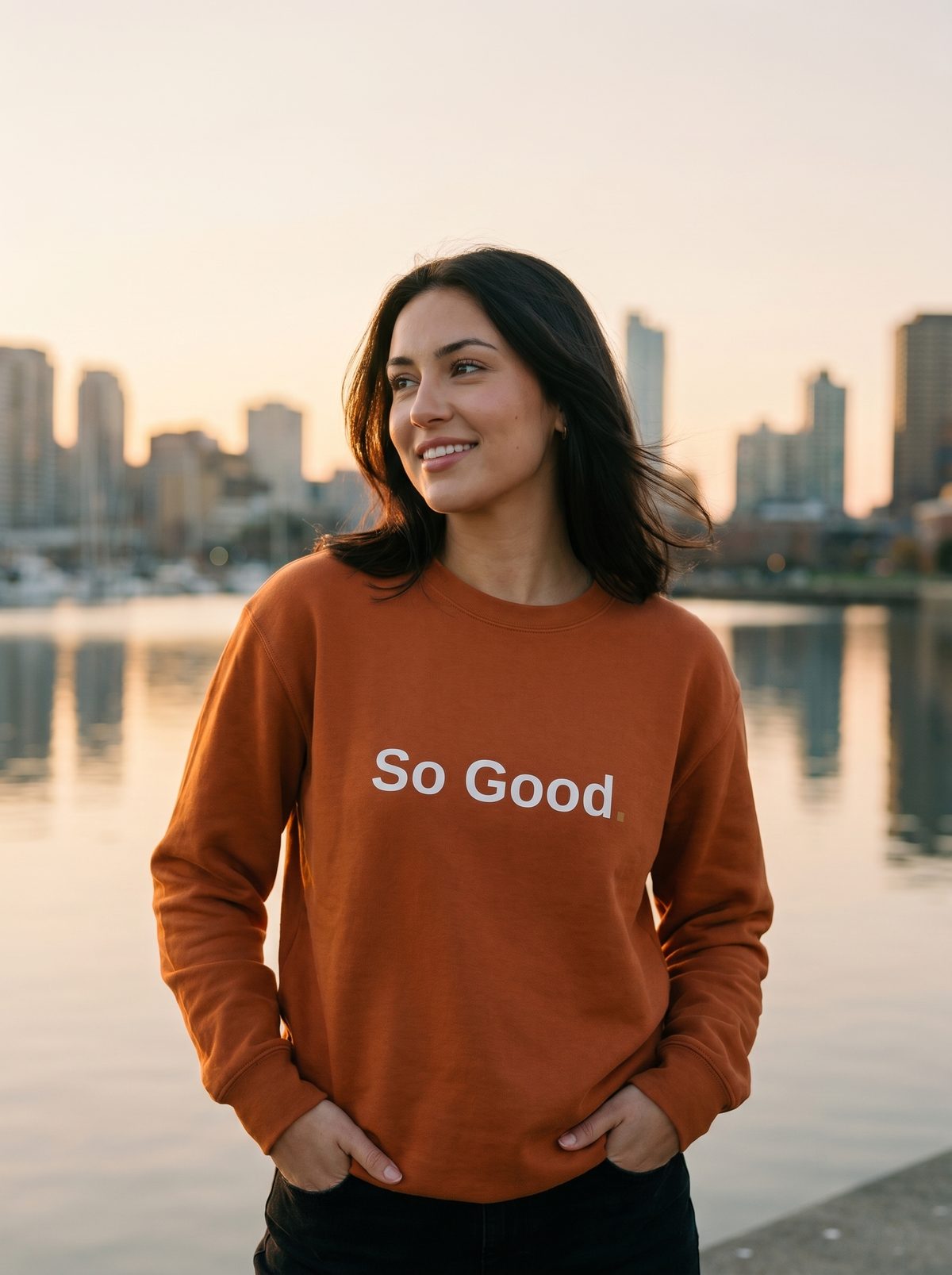 Crewneck adobe So Good. Drop 01 Sunset, porté au bord de l'eau au coucher de soleil en ville.